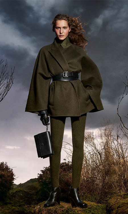 Max-Mara-Look der Kampagne Untamed Heroine mit kurzem Mantel und Leggings in Moosgrün und Tasche aus Leder.