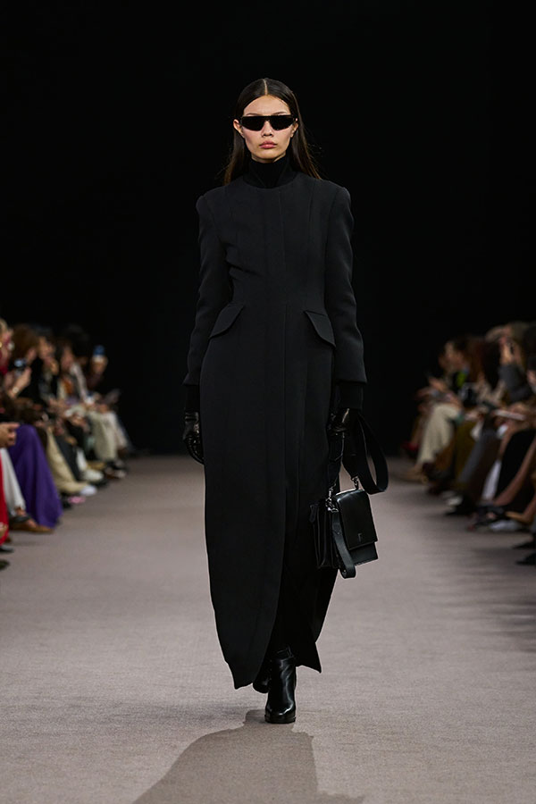 Max-Mara-Show Herbst/Winter 2025 – Schwarzer Look mit brauner Sonnenbrille im Maskendesign, Umhängetasche aus Leder, Bootie.