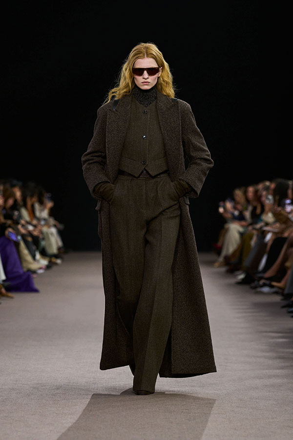 Max-Mara-Show Herbst/Winter 2025 – Brauner Look mit Sonnenbrille, Weste, langen Handschuhen und Hose mit weitem Bein.