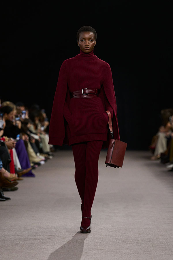 Max-Mara-Show Herbst/Winter 2025 – Look in Kirschrot mit Cape-Kleid, Gürtel, kleiner Umhängetasche und Mary-Jane-Schuhen