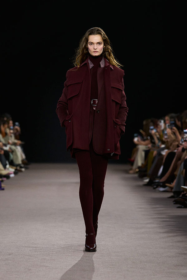 Max-Mara-Show Herbst/Winter 2025 – Look in Kirschrot mit langer Weste, einreihigem Blazer, Minirock und Leggings.