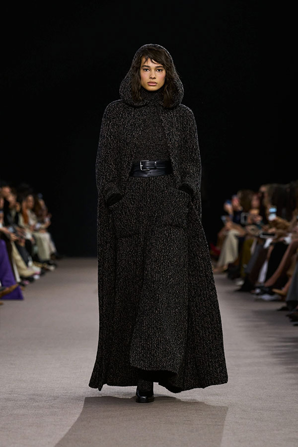 Max-Mara-Show Herbst/Winter 2025 – Look in Kamelbraun mit langem Cape, Rollkragenpullover, ausgestelltem Rock und Mary-Janes.