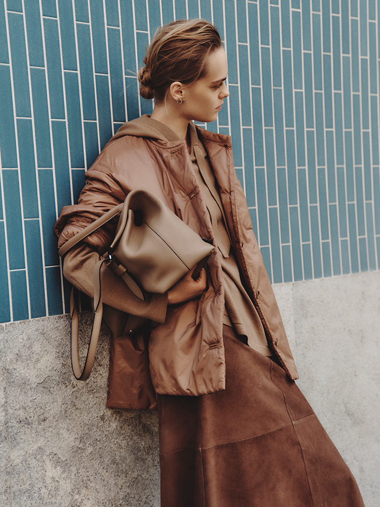 Model mit wattierter Max Mara The Cube Hemdjacke mit abgerundeten Seitenschlitzen sowie einem etwas längeren Saum hinten.