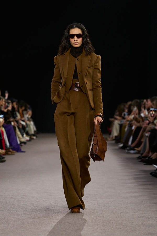 Max-Mara-Show Herbst/Winter 2025 – Lederlook mit Sonnenbrille, kurzer Jacke, Umhängetasche und Hose mit weitem Bein.