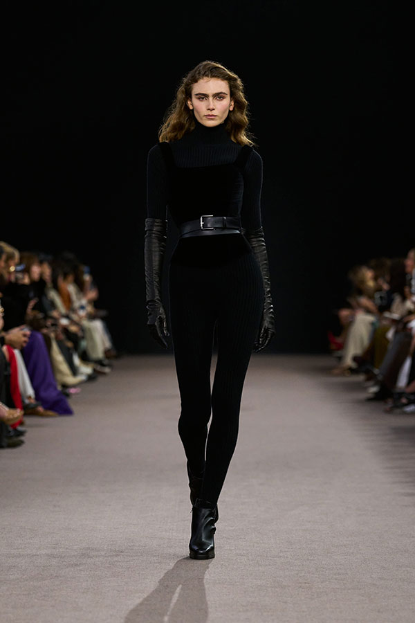 Max-Mara-Show Herbst/Winter 2025 – Schwarzer Look mit Rollkragenpullover, Bustiertop aus Samt, Gürtel, Leggings und Bootie. 
